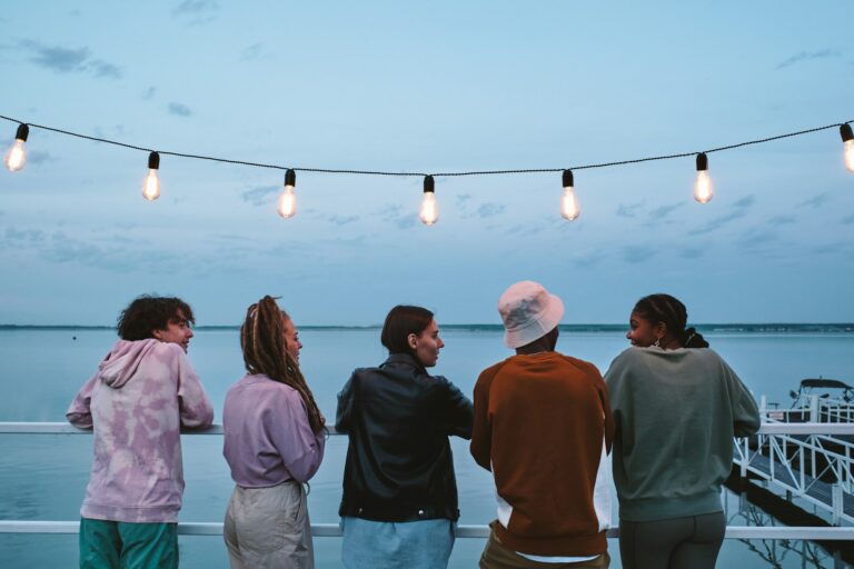 Group of young friends looking at African girl during conversation